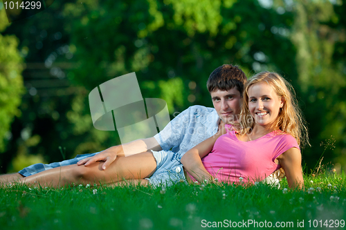 Image of Couple resting on the grass in the park