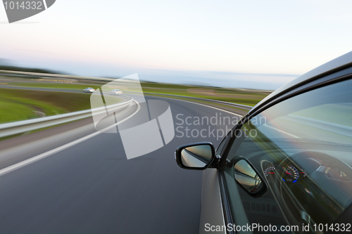 Image of Car goes very fast to turn a country road