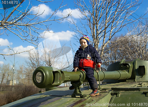 Image of The boy sitting on the tank