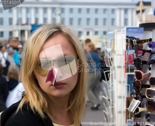 Image of The girl tries on sun glasses