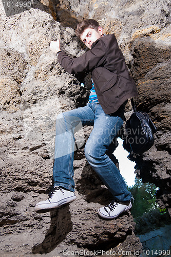 Image of Trendy man climbing in the cave