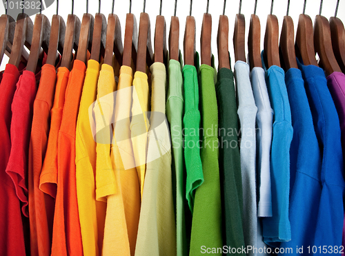 Image of Colors of rainbow, clothes on wooden hangers