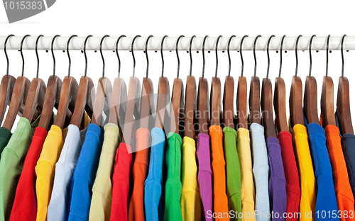 Image of Multicolored clothes on wooden hangers