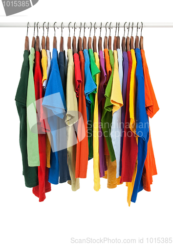 Image of Variety of multicolored shirts on wooden hangers