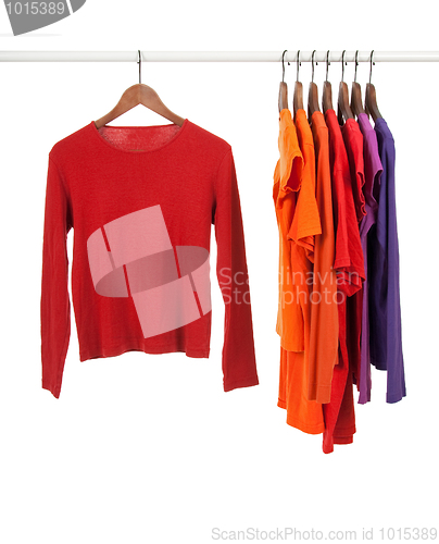 Image of Red and purple shirts on wooden hangers