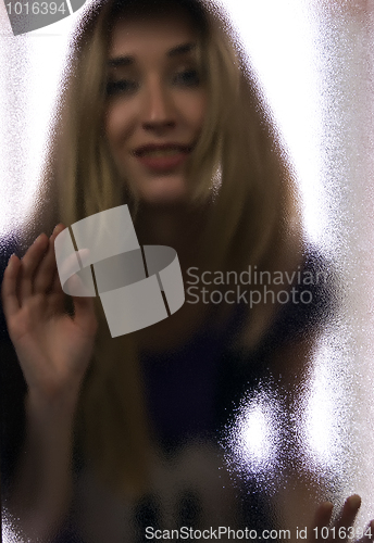 Image of Girl behind the glass  door  