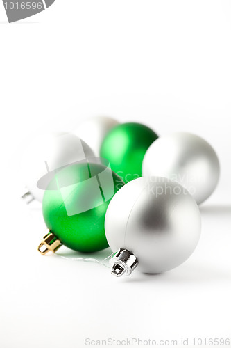 Image of Green and silver Christmas baubles on white