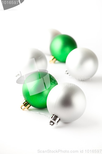 Image of Green and silver Christmas baubles on white