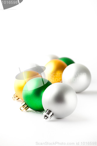 Image of Green, gold and silver Christmas baubles on white