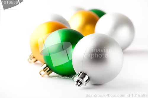 Image of Green, gold and silver Christmas baubles on white