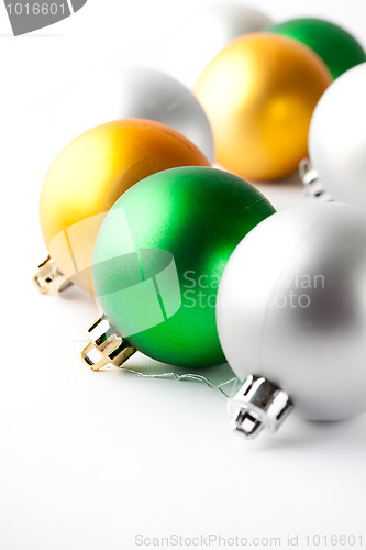Image of Green, gold and silver Christmas baubles on white