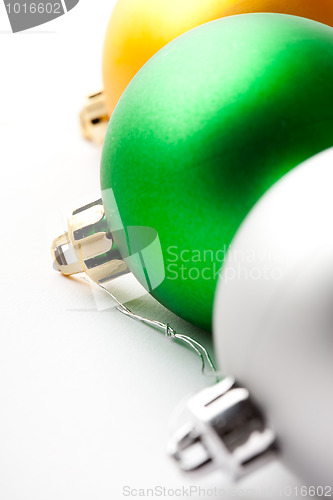 Image of Green, gold and silver Christmas baubles on white