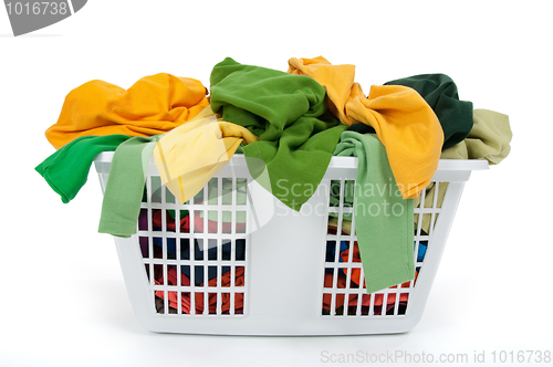 Image of Colorful clothes in laundry basket. Green, yellow.