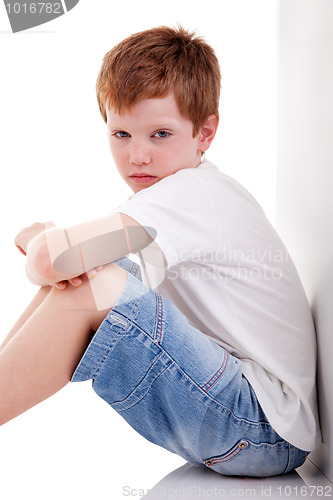 Image of cute boy, sitting on the floor tired