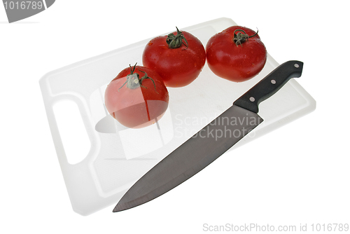 Image of Cutting board with a knife and tomato