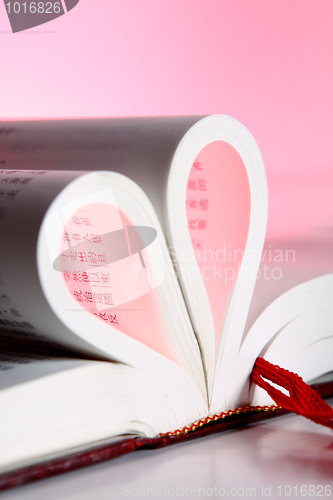 Image of pages of a book curved into a heart shape 