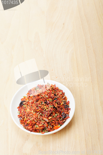 Image of Saucer with spice mixture for rice courses on wood