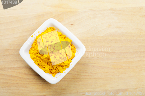 Image of Saffron spice in white dish on wooden board