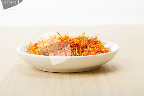 Image of Saffron leaves spice in dish on wood