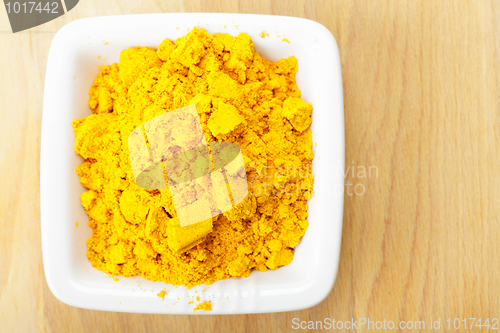 Image of Saffron spice in white dish on wood closeup
