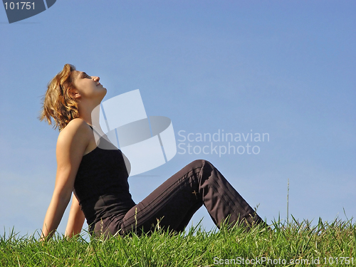 Image of Beautiful woman sitting in the grass