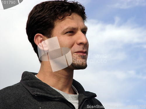 Image of Young man against the blue sky