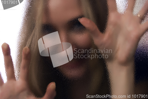 Image of Girl behind the glass  door  