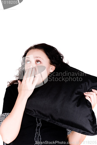 Image of beautiful yawning woman holding a pillow