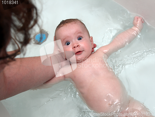 Image of baby girl bath by mother