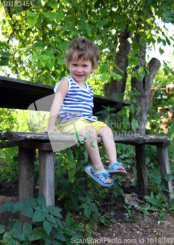 Image of happy baby sitting in garden