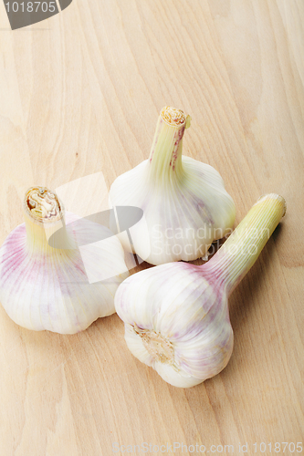 Image of Three garlic bulbs on wood