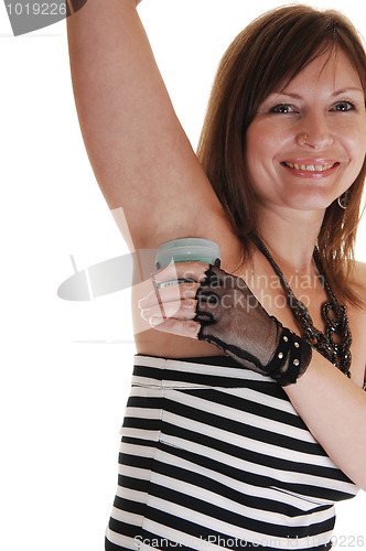 Image of Girl putting deodorant on.