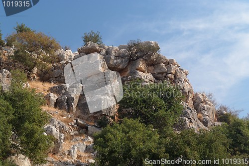 Image of Steep weathered cliff in bright summer day