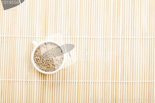 Image of Caraway spice seeds in cup on mat