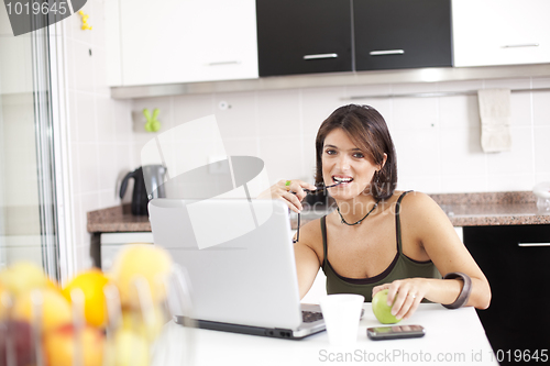 Image of Modern woman reading e-mails at her breakfast