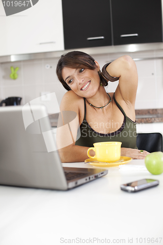 Image of Modern woman reading e-mails at her breakfast