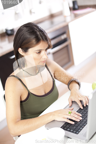 Image of Modern woman reading e-mails at her breakfast