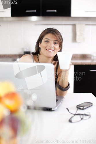 Image of Modern woman reading e-mails at her breakfast