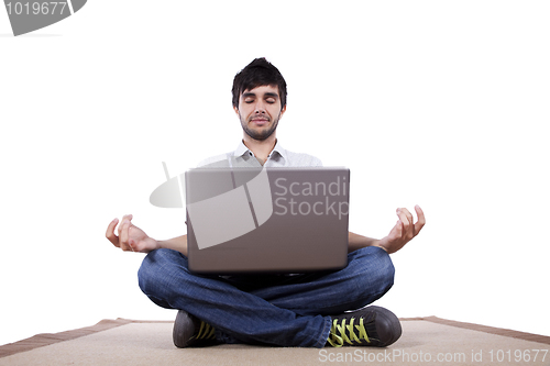 Image of Young man meditating with his laptop