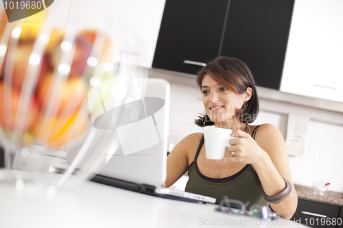 Image of Modern woman reading e-mails at her breakfast