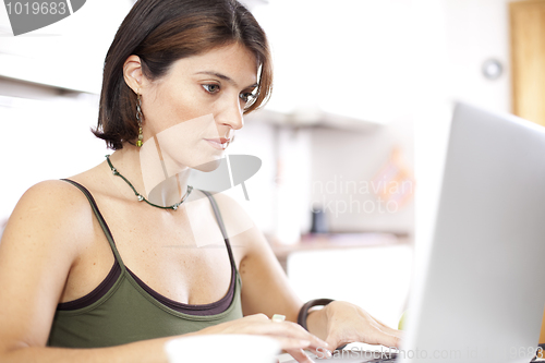 Image of Modern woman reading e-mails at her breakfast