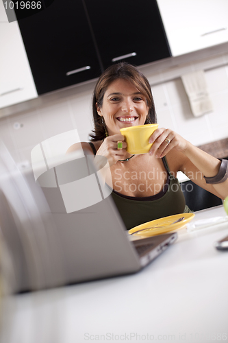 Image of Modern woman reading e-mails at her breakfast