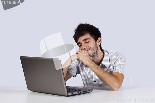 Image of Young man dreaming in front of his laptop