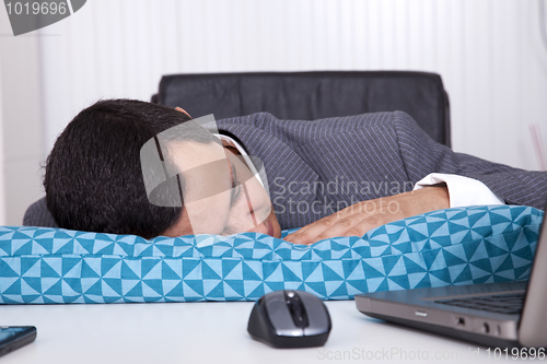 Image of Businessman sleeping at the office