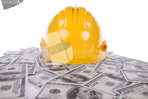 Image of Construction helmet over a lot of money