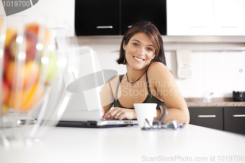 Image of Modern woman reading e-mails at her breakfast