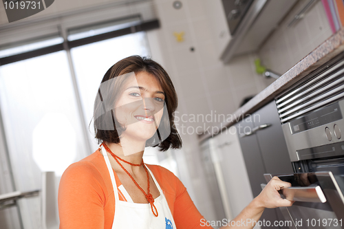 Image of Woman opening the kitchen oven