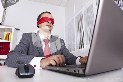 Image of Blindfold businessman working with his laptop