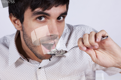 Image of Man eating little dollar banknote