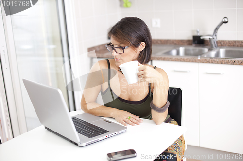 Image of Modern woman reading e-mails at her breakfast